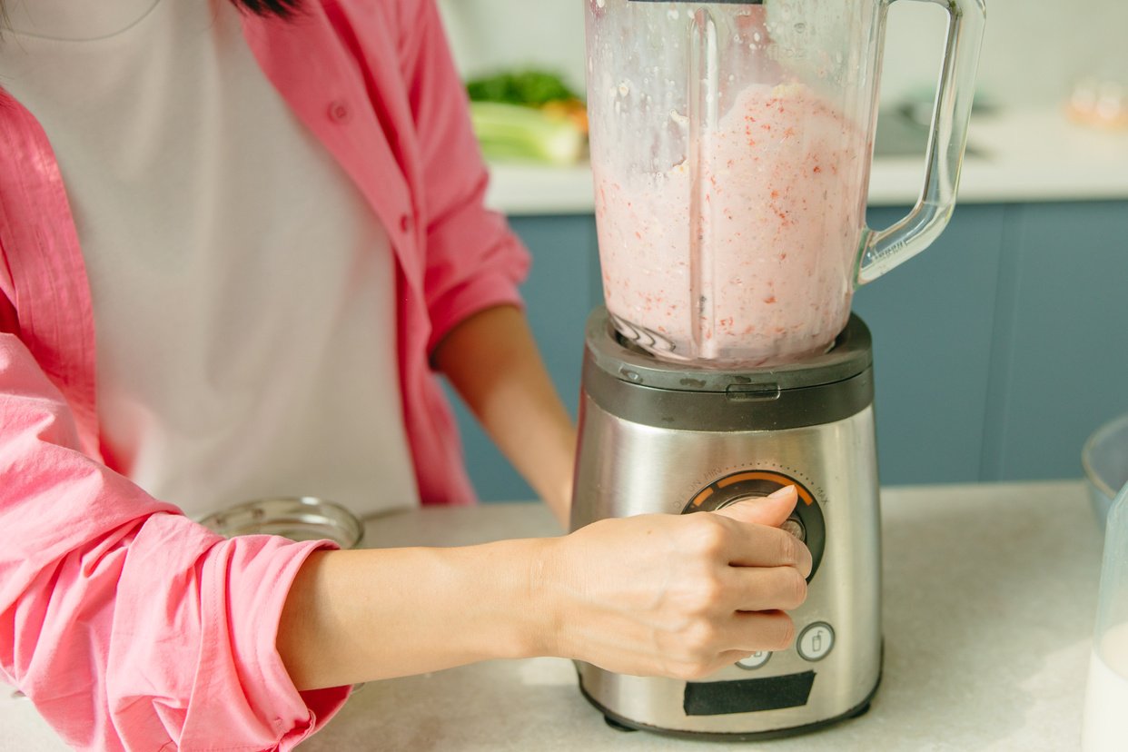 Hand of a Person Operating a Blender